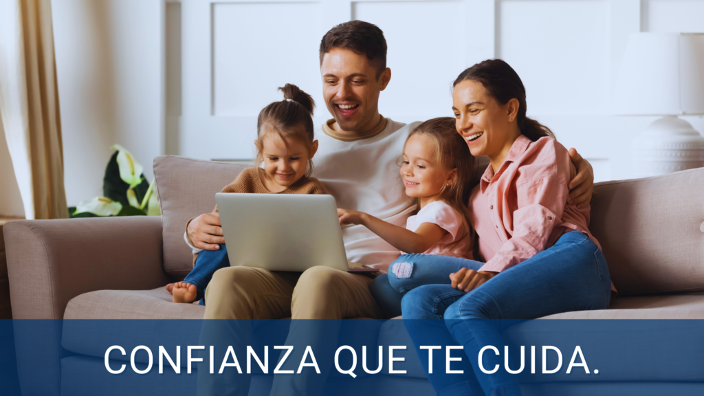 Familia sonriente sentada junta en un sofá mientras miran una computadora portátil, simbolizando la protección y confianza que brindan nuestros seguros