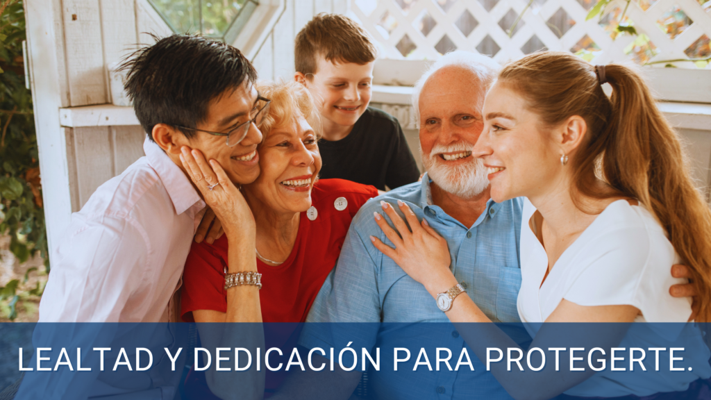 Familia multigeneracional feliz abrazándose y sonriendo en un entorno acogedor, representando la protección y dedicación con lealtad de nuestros seguros.